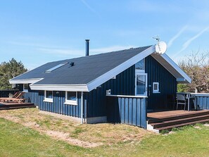 A single-story house with a dark blue exterior, a sloped roof, and a visible chimney. - 4 Star Holiday Home in Lokken (Lokken)