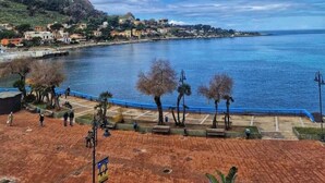 A coastal town with a view of the sea, a paved promenade, and buildings along the shore. - Cozy 1-bedroom apartment in front of the sea (Palermo)
