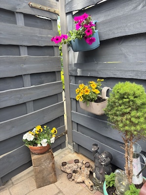 A wooden fence with flower planters and a small tree.
