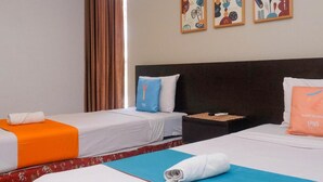 A hotel room with two beds, a nightstand, and three wall art pieces. - Prime Cailendra Hotel Tamansiswa Yogyakarta (Yogyakarta)