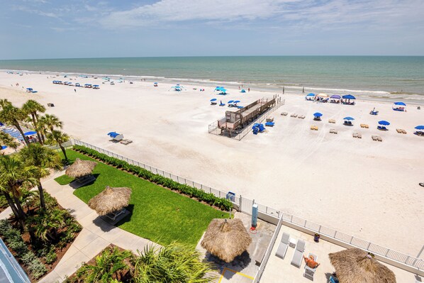 A beach resort with a pool area, lounge chairs, and umbrellas. - Direct Beachfront Penthouse (Indian Shores)