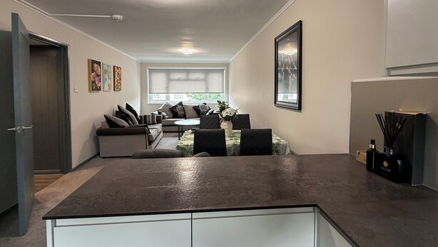 Una cocina moderna con comedor, un ventanal grande y una puerta que da a otra habitación.