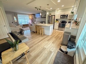 A modern kitchen with a central island, wooden flooring, and built-in appliances.