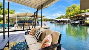 A covered outdoor seating area with a view of a water body and docked boats.
