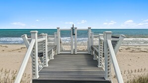 Une promenade en bois menant à la plage, d’où l’on a une vue dégagée sur l’océan.