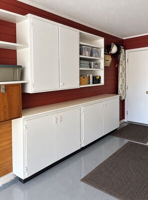 A kitchen with white cabinets, a wooden cabinet, and a white door. - Beautifully Remodeled 4BR Phoenix Desert Garden Retreat (Phoenix)