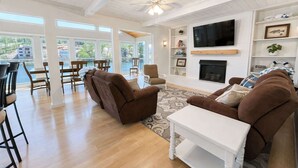 A spacious living room with a fireplace, a television, and a view of the outdoors. - Lakeside Escape with Boat Slip (Rocky Mount)