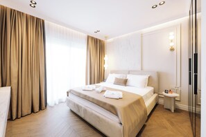 A hotel room with a large bed, bedside tables, a TV, and a window with curtains. - Hotel Dolcinium (Ulcinj)