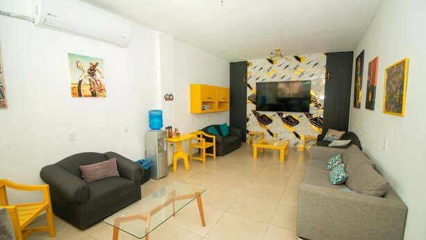 A living room with a sofa, a coffee table, a TV, and artwork on the walls. - Hotel Santa María (Mazatlán)
