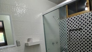 A bathroom with a white sink, toilet, and glass-enclosed shower. - Hotel Santa María (Mazatlán)