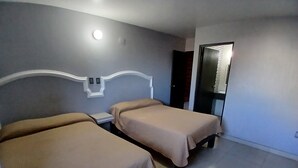 A hotel room with two beds, a nightstand, a mirror, and a door. - Hotel Santa María (Mazatlán)
