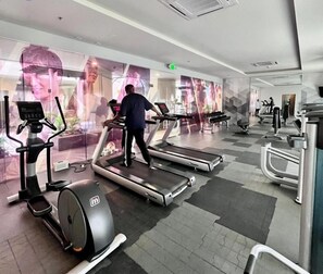 Et træningscenter med løbebånd, crosstrainere og vægtbænke.