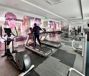 A gym with treadmills, elliptical machines, and weight benches. - Relaxing Iloilo Stay with Pool Access (Iloilo City)