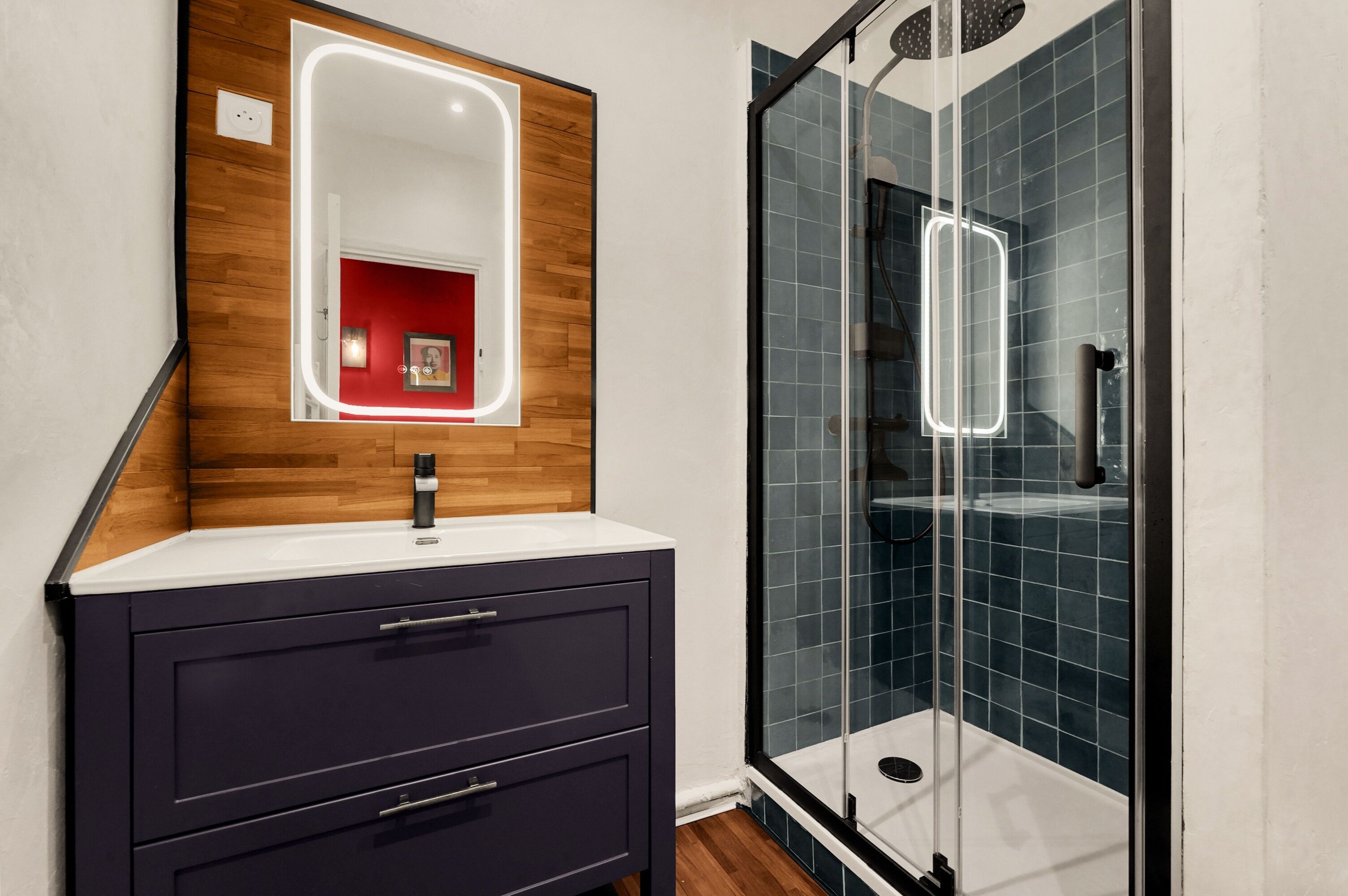 Une salle de bain avec un meuble-lavabo en bois, un miroir et une douche à parois de verre.