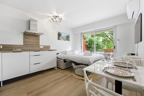 Ein modernes Schlafzimmer mit Bett, Nachttisch und Blick ins Freie.