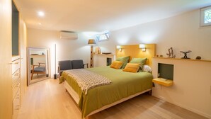 Ein Schlafzimmer mit Bett, Nachttisch, Lampe und einem kleinen Regal mit Dekoration.