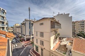 Ein mehrstöckiges Gebäude mit Balkonen, Blick auf eine Straße und blauem Himmel.