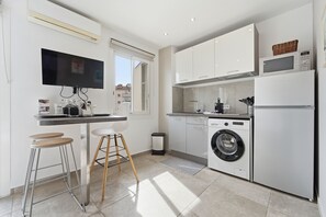 Eine moderne Küche mit Waschmaschine, Mikrowelle und Fernseher.
