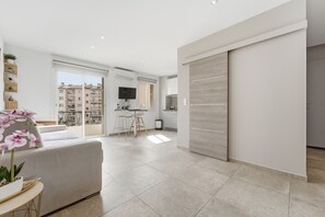 Eine moderne Wohnung mit Wohnbereich, Küche und Balkon.