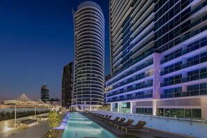A modern hotel with a pool, multiple floors, and a curved facade. - Residence Surfers Ocean and Pool Views (Surfers Paradise)