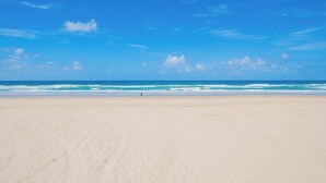 A beach with a clear sky, ocean waves, and a lifeguard tower. - L17 Spacious Central 2BR Wi-Fi (Surfers Paradise)