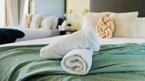 A hotel room with two beds, a green bedspread, and rolled white towels. - Ocean View studio 2 Beds, Free Wi-Fi (Surfers Paradise)