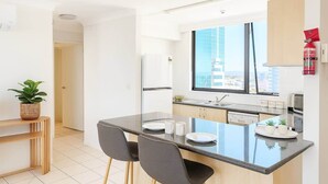 Une cuisine moderne dotée d’un îlot central, d’un coin repas et offrant une vue sur la ville.
