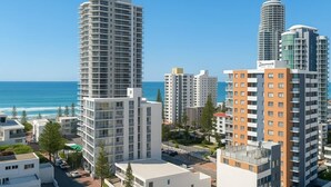 Un hôtel de grande hauteur au design moderne, situé près d’une plage où le ciel est dégagé.