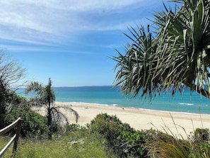 A beach with clear skies, a sandy shore, and some greenery in the foreground. - Resort Retreat in Circle: 2BR Stay & SPA (Surfers Paradise)