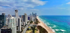 A coastal cityscape with high-rise buildings, a beach, and a clear sky. - Level 25 Broadbeach Escape Pool Gym (Broadbeach)