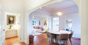 A modern interior with a dining area, a sofa set, and a framed picture on the wall.
