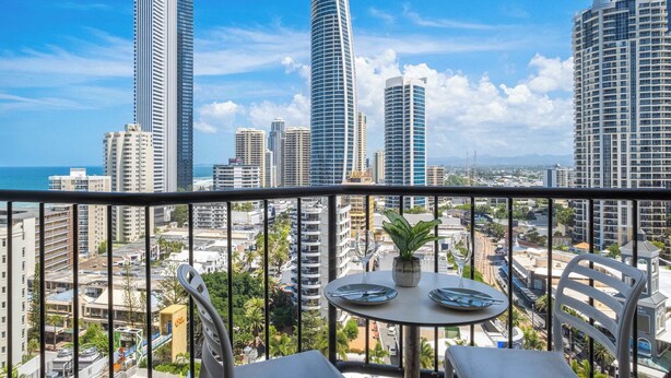 A balcony with a table, chairs, and a potted plant. - L15 Ocean View Suite with 2 Beds (Surfers Paradise)
