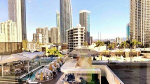 A high-rise hotel with a rooftop pool, multiple dining areas, and a view of the city skyline. - High Floor King Studio Surfers (Surfers Paradise)