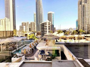 A high-rise hotel with a rooftop pool, multiple dining areas, and a view of the city skyline. - High Floor King Studio Surfers (Surfers Paradise)