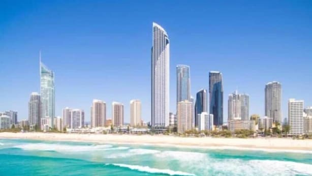 Horizontale Skyline einer Küstenstadt mit hohen Wolkenkratzern, einem Strand und klarem, blauem Wasser.