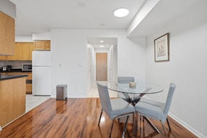 A modern kitchen with wooden cabinets, a stainless steel refrigerator, and a built-in oven. - Modern 1BR Downtown Condo w/ Private Balcony Views (Toronto)