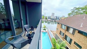 Un balcone con piscina, sedie e vista sulla città.