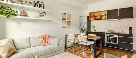 A modern living room with a sofa, coffee table, and dining area.