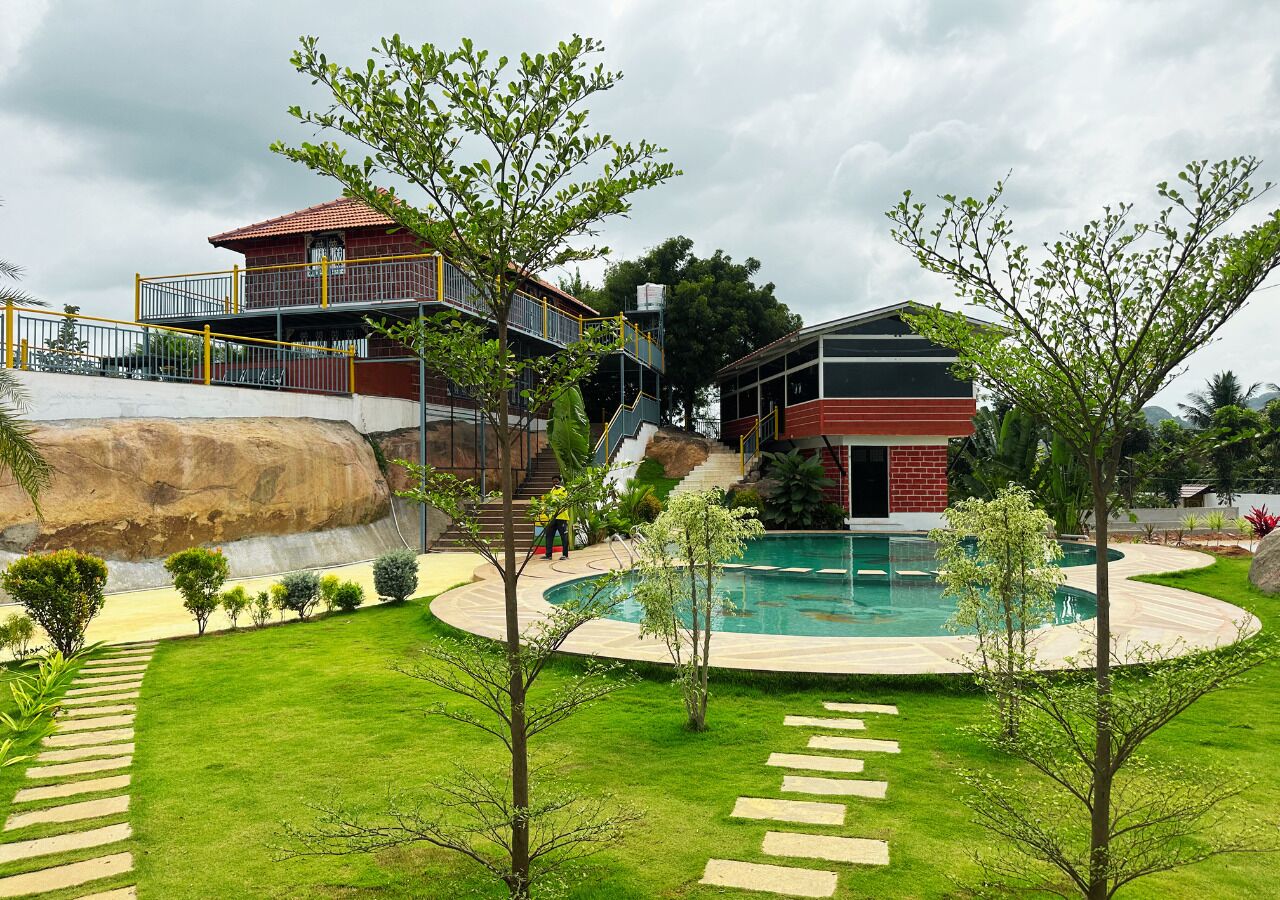 Una propiedad residencial con piscina, una escalera que lleva a un balcón y un césped bien cuidado.
