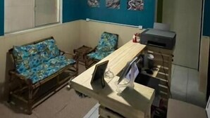 A room with a ceiling fan, a sofa, a small table, and a cabinet. - Quintal do Mar Hostel (Salvador)