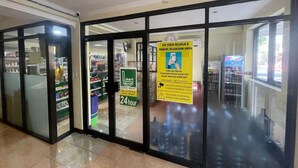 A mall entrance with a 24-hour sign, glass doors, and a visible store in the background. - Cozzy Galaxy Hotel (Manado)