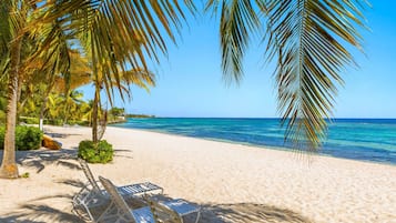 On the beach, white sand, sun-loungers, beach umbrellas