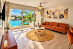 Uma sala de estar moderna com um sofá, uma mesa de centro e vista para uma piscina.