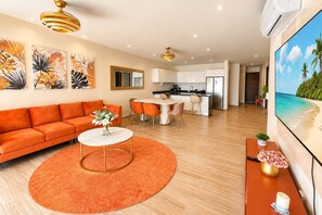 A modern living room with a sofa, a round coffee table, and a dining area with chairs. - Canal view, pool, 7-min walk to beach (Puerto Aventuras)