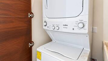 Un appareil combiné lave-linge et sèche-linge, de type « empilable », doté de boutons de commande et d’une étiquette sur la partie inférieure.