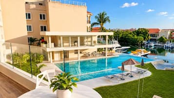 Ein Hotel mit Pool, Außenbereich und Blick auf den Yachthafen.