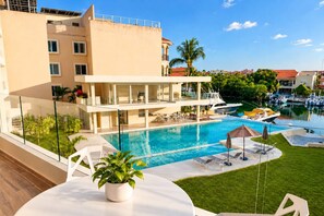 Un hotel con piscina, zona de estar al aire libre y vistas al puerto deportivo.