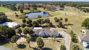 A residential area with houses, a golf course, and a pond. - Sunset Palms, lake view-Near manatees, golf & scalloping (Crystal River)