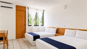 Una habitación de hotel con dos camas, cabecero de madera, un escritorio y una ventana con cortinas.