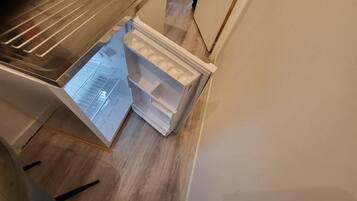 An open refrigerator with multiple shelves and a freezer compartment.